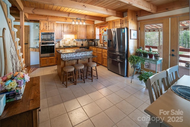 kitchen featuring a sink, beam ceiling, stainless steel appliances, wooden ceiling, and backsplash