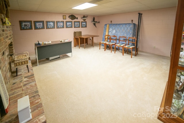 sitting room featuring concrete block wall and carpet