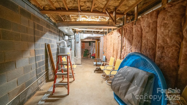 unfinished below grade area with concrete block wall and gas water heater