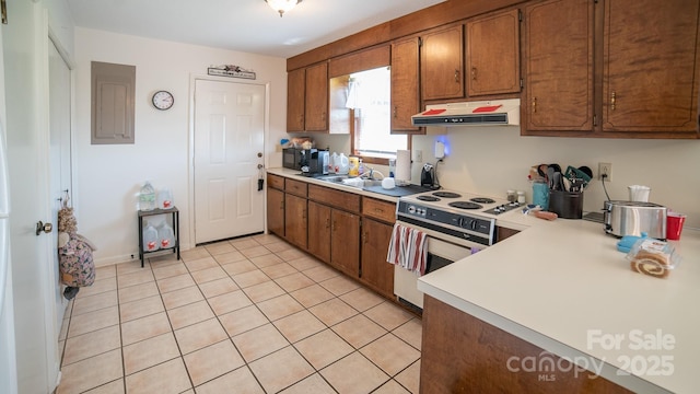 kitchen featuring brown cabinetry, light countertops, under cabinet range hood, and white range with electric cooktop