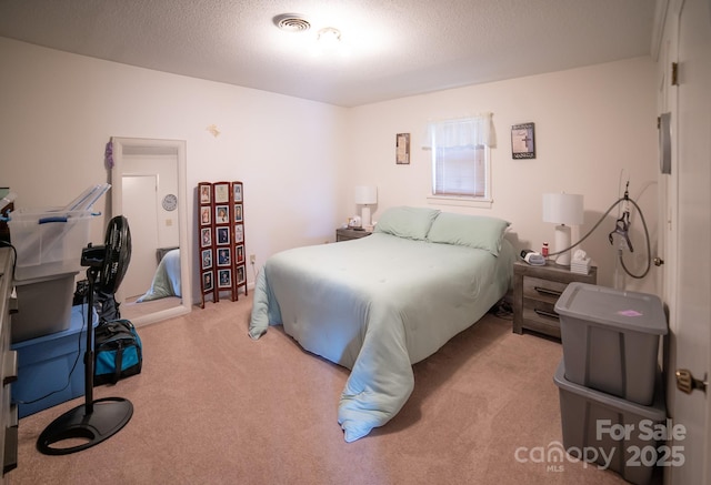 carpeted bedroom featuring a textured ceiling and visible vents