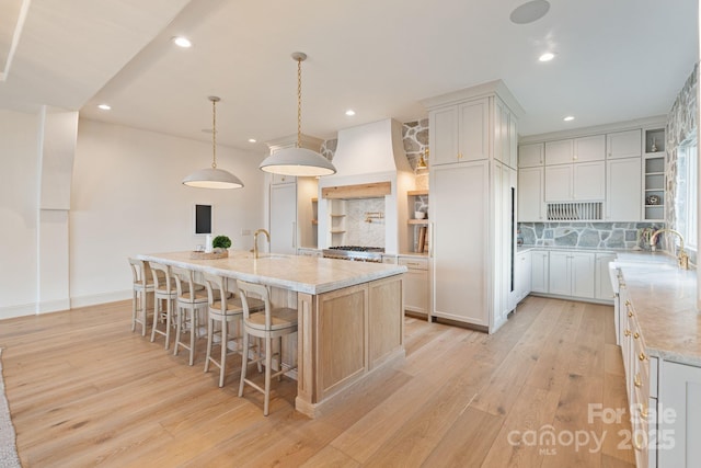 kitchen featuring recessed lighting, open shelves, custom range hood, and light wood-type flooring