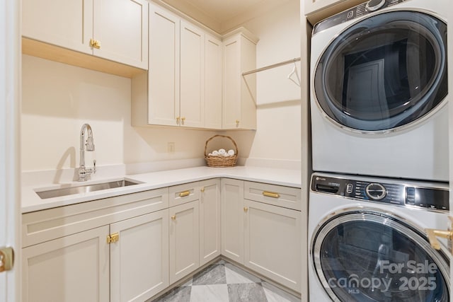 washroom with a sink, cabinet space, and stacked washing maching and dryer