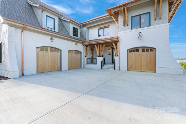 mediterranean / spanish house with a garage, concrete driveway, and brick siding