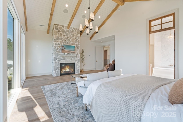 7679 Rabbit Cir, Denver, NC 28037 - bedroom featuring a chandelier, high vaulted ceiling, light wood-style floors, a stone fireplace, and wood ceiling with exposed beams