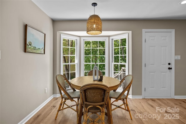 dining area with light wood-style flooring and baseboards