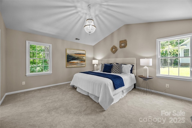 carpeted bedroom featuring lofted ceiling, a chandelier, and baseboards
