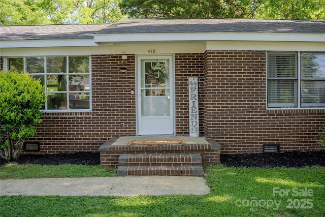 entrance to property featuring brick siding and crawl space