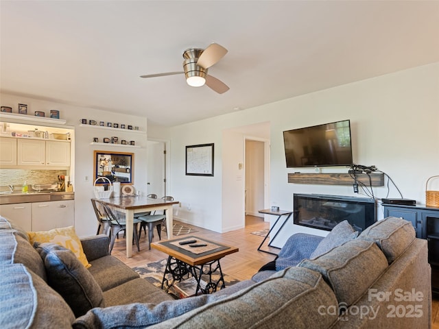 62 Cosmic Ln, Waynesville, NC 28786 - living room featuring a ceiling fan, a glass covered fireplace, and baseboards