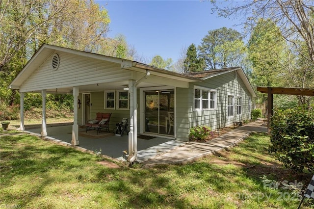 rear view of property featuring a yard and a patio area