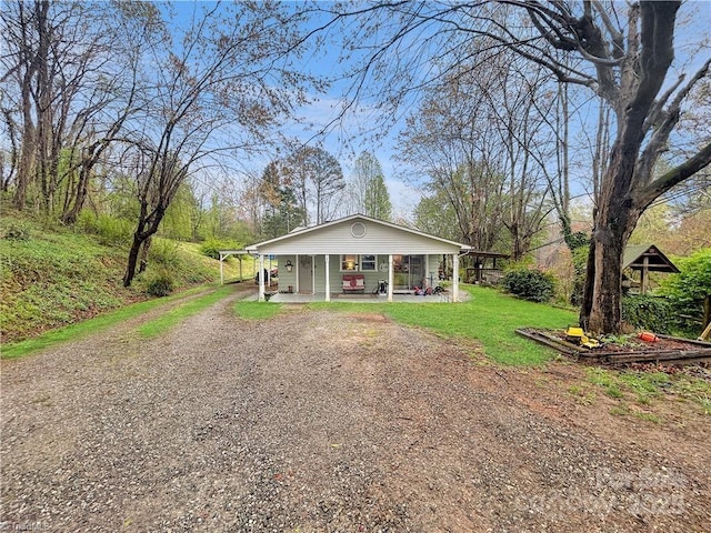 bungalow-style home featuring driveway, a front yard, and covered porch