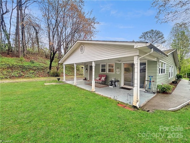 rear view of property with a patio area and a yard