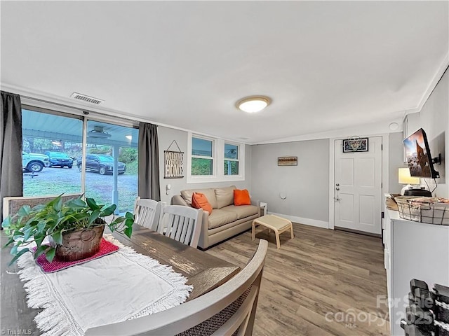living area with baseboards, wood finished floors, and visible vents