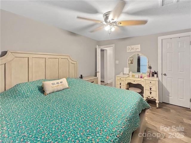 bedroom featuring wood finished floors, visible vents, and ceiling fan