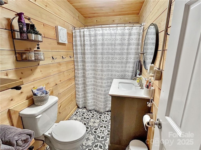 bathroom featuring wood walls, vanity, and toilet