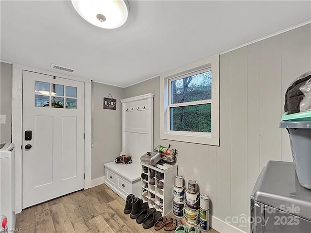 mudroom with light wood-style floors, baseboards, visible vents, and washer and dryer