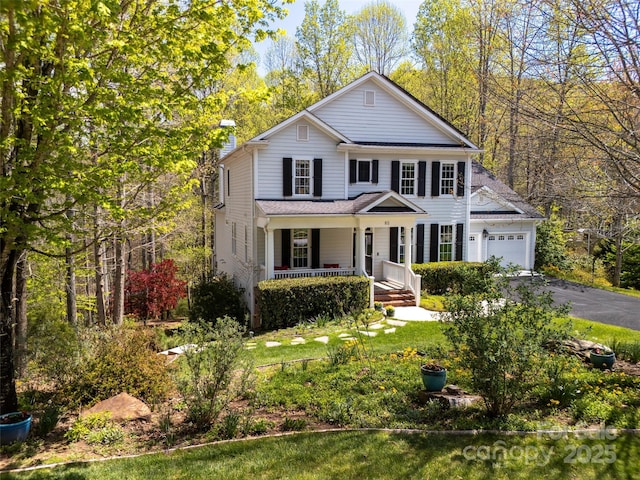 view of front of property with aphalt driveway, a garage, and covered porch