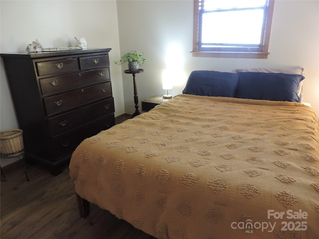 bedroom featuring dark wood finished floors and baseboards