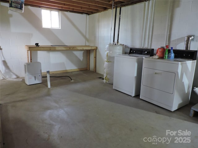 basement with washer and dryer and concrete block wall