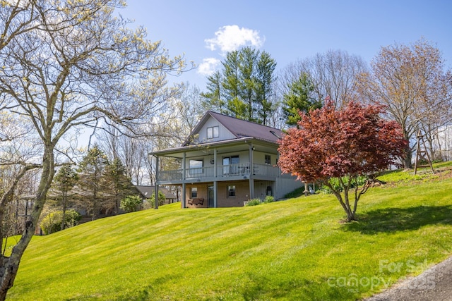 back of property featuring a lawn and a deck