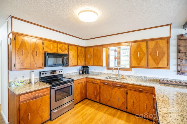 kitchen featuring a textured ceiling, a sink, black microwave, stainless steel electric stove, and light wood-style flooring