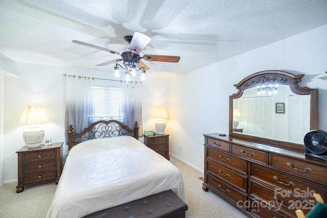 bedroom featuring a textured ceiling, a ceiling fan, baseboards, and light carpet