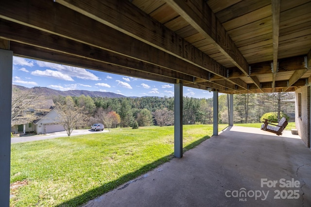 view of patio featuring a forest view and a mountain view