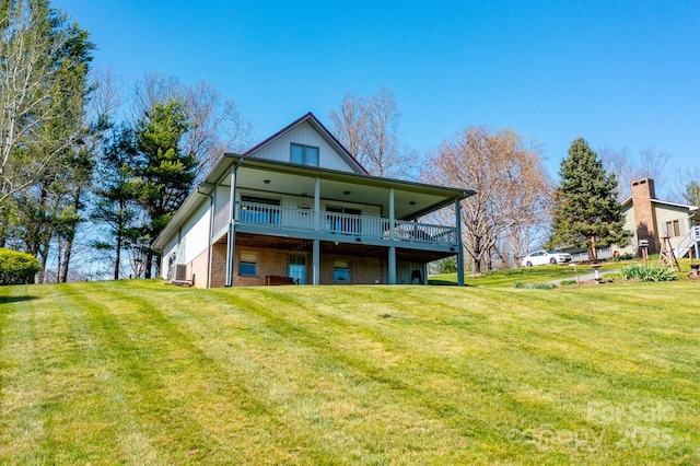 rear view of house with a wooden deck and a yard