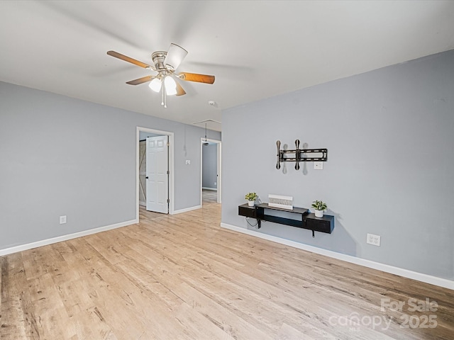 spare room featuring ceiling fan, wood finished floors, and baseboards
