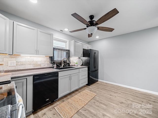 kitchen featuring black appliances, a sink, a ceiling fan, decorative backsplash, and baseboards