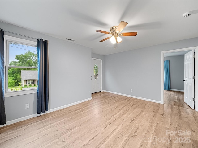 unfurnished room featuring ceiling fan, light wood-style flooring, and baseboards