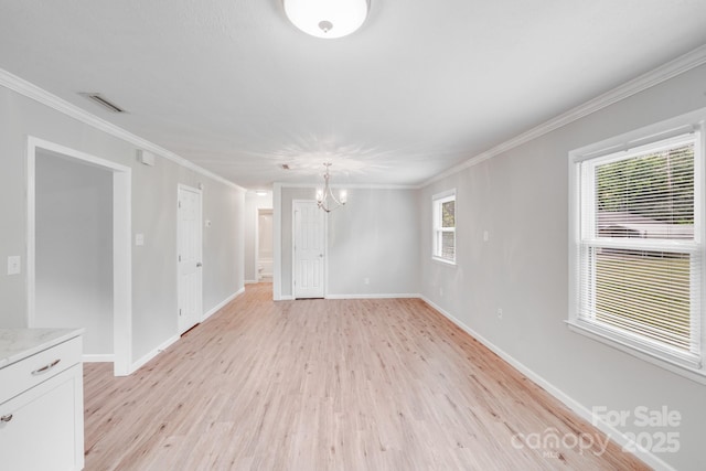 empty room with a chandelier, light wood-style flooring, visible vents, and ornamental molding