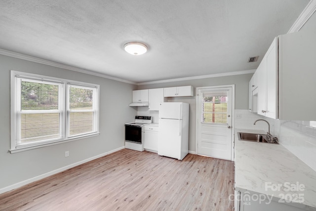 kitchen with a sink, range with electric stovetop, under cabinet range hood, visible vents, and freestanding refrigerator