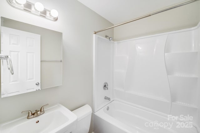 bathroom featuring shower / bath combination, a sink, and toilet