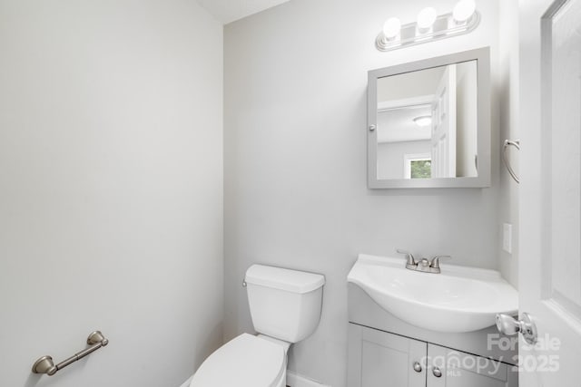 half bathroom featuring vanity and toilet