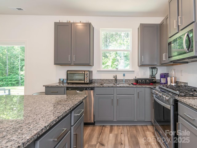 11010 Redcoat Hill Ln, Huntersville, NC 28078 - kitchen featuring appliances with stainless steel finishes, a sink, gray cabinets, and plenty of natural light