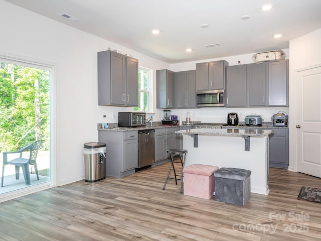 11010 Redcoat Hill Ln, Huntersville, NC 28078 - kitchen with stainless steel appliances, gray cabinetry, a kitchen bar, plenty of natural light, and recessed lighting