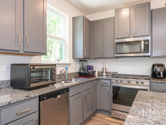 11010 Redcoat Hill Ln, Huntersville, NC 28078 - kitchen with stainless steel appliances, gray cabinetry, a sink, and light wood-style floors