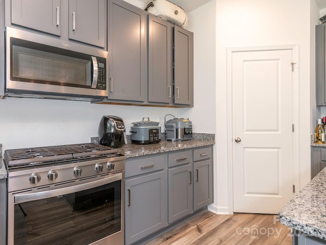 11010 Redcoat Hill Ln, Huntersville, NC 28078 - kitchen with stainless steel appliances, gray cabinetry, light wood-style floors, and light stone counters