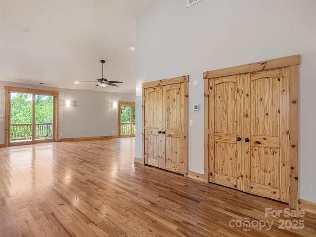 15 Sassy Ln, Asheville, NC 28805 - unfurnished living room featuring light wood-style floors, healthy amount of natural light, ceiling fan, high vaulted ceiling, and baseboards