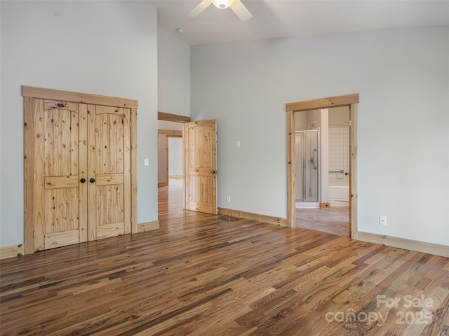 15 Sassy Ln, Asheville, NC 28805 - unfurnished bedroom featuring high vaulted ceiling, wood finished floors, baseboards, ensuite bath, and a ceiling fan