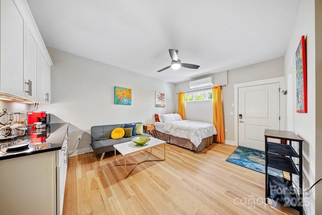 1115 Greenleaf Ave Unit B, Charlotte, NC 28202 - bedroom featuring baseboards, a ceiling fan, light wood finished floors, and a wall mounted air conditioner