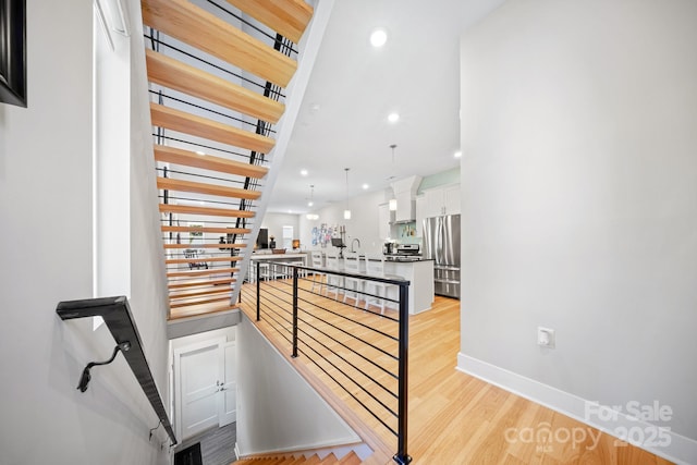 1115 Greenleaf Ave Unit B, Charlotte, NC 28202 - corridor with baseboards, recessed lighting, a sink, light wood-style flooring, and an upstairs landing