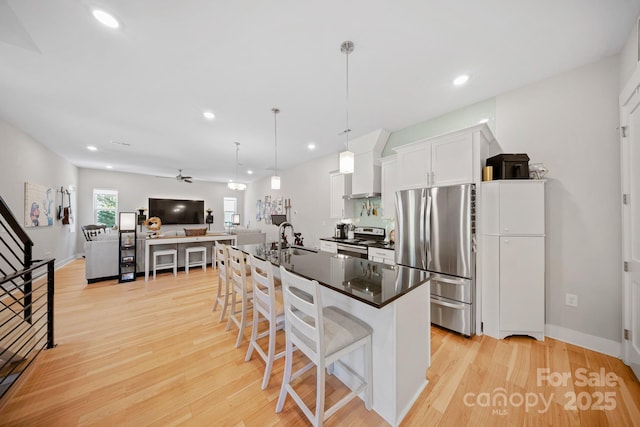 1115 Greenleaf Ave Unit B, Charlotte, NC 28202 - kitchen featuring dark countertops, a sink, light wood-style flooring, stainless steel appliances, and a kitchen bar