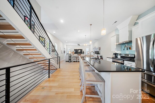 1115 Greenleaf Ave Unit B, Charlotte, NC 28202 - kitchen featuring a sink, light wood finished floors, open floor plan, stainless steel appliances, and white cabinetry