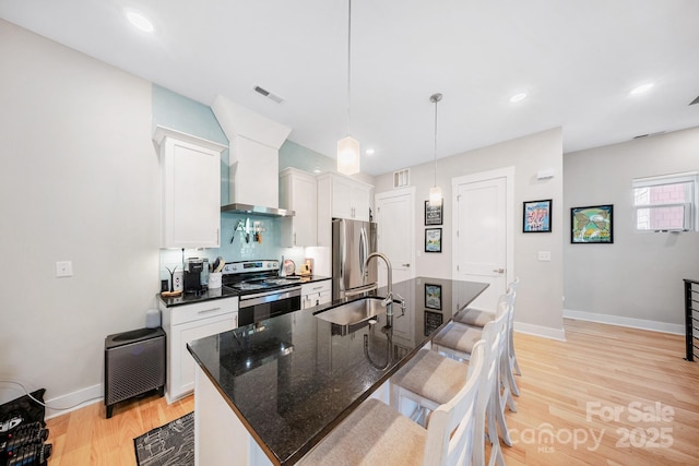 1115 Greenleaf Ave Unit B, Charlotte, NC 28202 - kitchen featuring visible vents, a breakfast bar area, a sink, light wood-style flooring, and appliances with stainless steel finishes