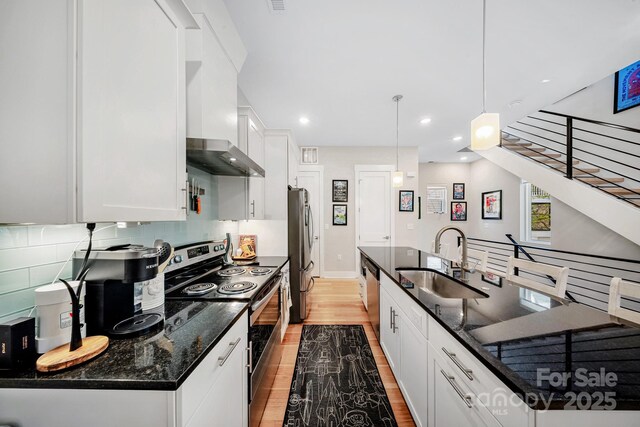 1115 Greenleaf Ave Unit B, Charlotte, NC 28202 - kitchen with decorative backsplash, light wood-type flooring, a sink, stainless steel appliances, and white cabinetry