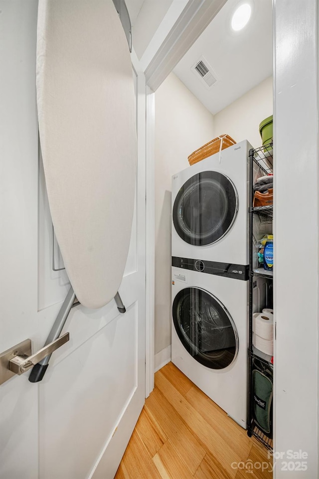 1115 Greenleaf Ave Unit B, Charlotte, NC 28202 - clothes washing area featuring stacked washer / drying machine, visible vents, wood finished floors, and laundry area