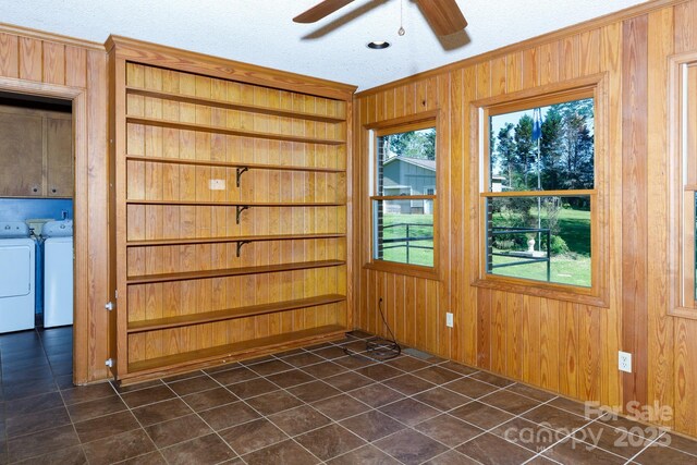 567 Willie Ln, York, SC 29745 - empty room featuring washing machine and clothes dryer, ceiling fan, crown molding, wooden walls, and dark tile patterned floors