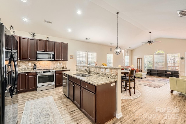 3939 Archer Notch Ln, Huntersville, NC 28078 - kitchen with stainless steel appliances, a breakfast bar, open floor plan, light wood-style floors, and a sink